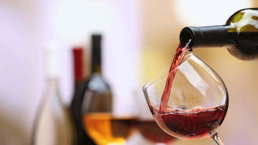 Roter Wein wird in ein Glas geschüttet