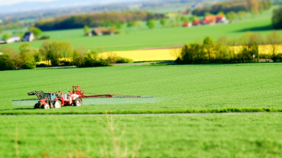weit entfernter Traktor mit Anhängespritze 
